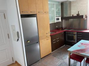 a kitchen with a stainless steel refrigerator and a table at Apartamento Elobey Cabo de Gata in El Cabo de Gata