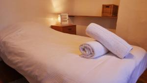 - un lit blanc avec 2 serviettes dans l'établissement Au charme d'antan en plein coeur du vieux Lille, à Lille