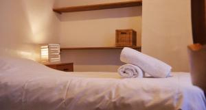 - un lit blanc avec des serviettes dans l'établissement Au charme d'antan en plein coeur du vieux Lille, à Lille