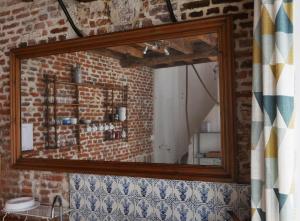 La salle de bains est pourvue d'un miroir et d'un mur en briques. dans l'établissement Au charme d'antan en plein coeur du vieux Lille, à Lille