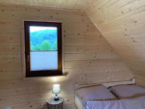 a room with two beds and a window in a log cabin at Domek u Kamińskich in Przyborów