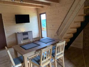 a dining room with a table and chairs in a cabin at Domek u Kamińskich in Przyborów