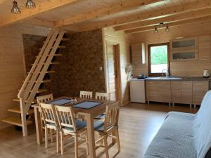 a kitchen and dining room with a table and stairs at Domek u Kamińskich in Przyborów