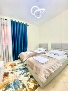 1 dormitorio con 2 camas y alfombra en Ideal Home, en Shkodër