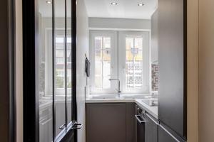 a kitchen with a sink and two windows and a mirror at Castel Saint Clair - Trois Pièces - Deauville Centre in Deauville