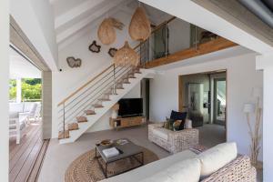 a living room with a staircase in a house at Villa Les Belles Vues de St Jean in Saint Barthelemy