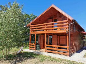 a log cabin with a porch and a tree at Brvnara koliba in Bor