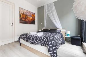 a bedroom with a bed with a black and white comforter at Apt B Boston, 25m2, Centre, Balcon 1 in Valenciennes