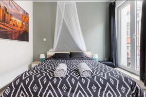1 dormitorio con 1 cama en blanco y negro y ventana en Apt B Boston, 25m2, Centre, Balcon, en Valenciennes