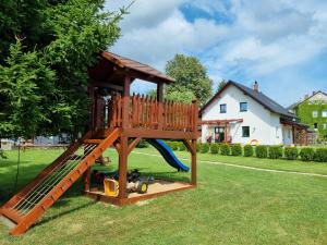 um playground com escorregador no quintal em Dům a chatka pod Smrkem em Nové Město pod Smrkem