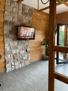 a living room with a stone wall and a television at Vila Grujic in Vrdnik