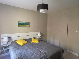 ein Schlafzimmer mit einem Bett mit zwei gelben Kissen in der Unterkunft Apartament Ukiel Bałtycka in Olsztyn