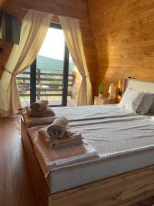 a bedroom with a bed with towels and a window at Vila Grujic in Vrdnik