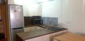 una pequeña cocina con fregadero y nevera. en Espectacular apartamento en la Isla de Tabarca, en Tabarca