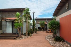 a courtyard with palm trees in front of a building at Majestic Oasis Apartments in Port Augusta