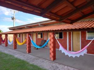a house with hammocks hanging from the outside at Pousada do Mané in Santo Amaro