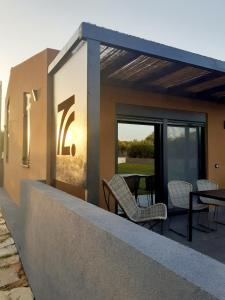 a balcony with chairs and tables on a building at The Zen Point detox suites in Marathopolis