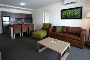 ein Wohnzimmer mit Couch und Tisch und eine Küche in der Unterkunft Quest Palmerston - Darwin in Darwin + 23 Fotos