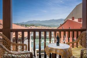 a table with a glass of wine on a balcony at Apartamentos Calle Mayor 23 Llanes in Llanes