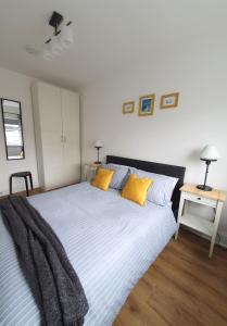 a bedroom with a large bed with yellow pillows at One Bed Apartment With Sofa Bed in Llandudno