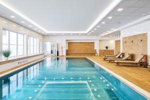 a pool in a hotel lobby with a swimming pool at Apartman Residence Moser 1504 in Karlovy Vary