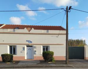 a white building with a blue door at Brisa Do Mar - Consolação in Peniche
