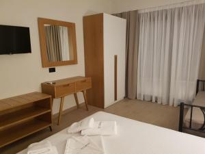 a bedroom with a bed and a dresser and a mirror at Amaryllis Luxury Living in Nea Vrasna