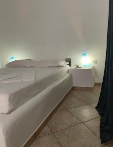 1 dormitorio con 1 cama blanca y mesita de noche en A View Home _ Agkistri, en Megalochori