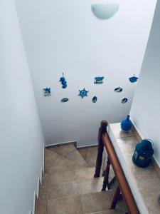 a staircase with fish stickers on a white wall at A View Home _ Agkistri in Megalochori