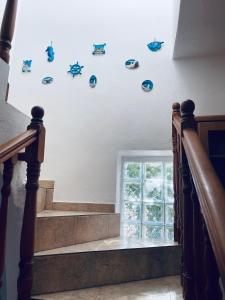 una escalera con calcomanías de pescado azul en la pared en A View Home _ Agkistri, en Megalochori