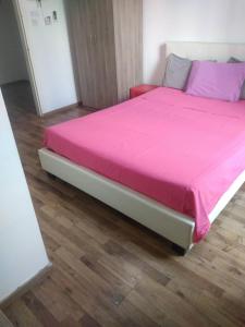 a large bed with a pink blanket on top of it at The Tony in Nicosia