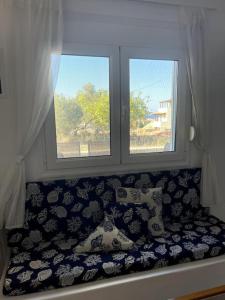 una ventana con un sofá delante en A View Home _ Agkistri, en Megalochori