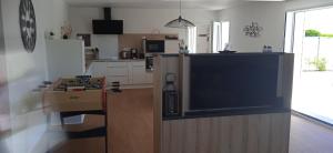 a living room with a large tv in a kitchen at maison de la plage des Amiets in Cléder