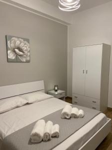 1 dormitorio blanco con 1 cama con 3 toallas en Appartamenti Al Fardella 365 en Trapani