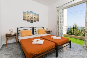 two beds in a room with a balcony at Irini's Sea View House in Sellía
