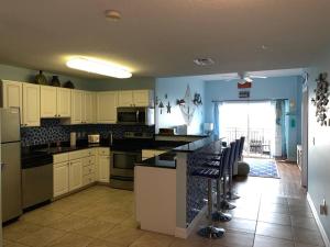uma cozinha com armários brancos e uma bancada em Two Bedroom Condo With Views Of The Beach & Gulf em St. Pete Beach