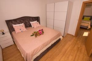 Un dormitorio con una cama con un ramo de flores. en Kuća za odmor MIRIS BORA, en Orebić