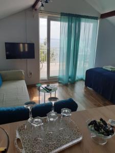 sala de estar con sofá y mesa con copas de vino en Adriatic, en Orebić