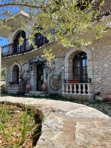 a stone house with a porch and a balcony at Solomon&Sons in Dhërmi