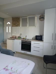 a kitchen with white cabinets and a stove top oven at Stone Guest House in Split