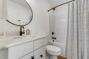 ein weißes Badezimmer mit Toilette und Spiegel in der Unterkunft Brookshire Townhome in Boone + 15 Fotos
