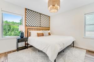 ein weißes Schlafzimmer mit einem Bett und einem Fenster in der Unterkunft Brookshire Townhome in Boone