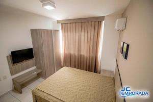 a small room with a bed and a television at Riviera Park in Caldas Novas