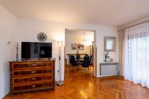 a living room with a television and a dining room at Casa Lilly in Labin