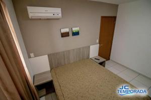 a small room with a bed and a air conditioner at Riviera Park in Caldas Novas
