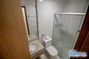 a bathroom with a toilet and a glass shower at Riviera Park in Caldas Novas
