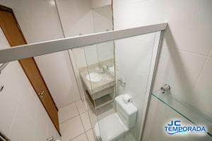 a small bathroom with a toilet and a sink at Riviera Park in Caldas Novas