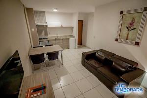 a living room with a couch and a kitchen at Riviera Park in Caldas Novas