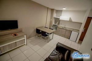 a small kitchen with a table and a television at Riviera Park in Caldas Novas