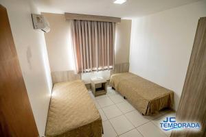 a hotel room with two beds and a window at Riviera Park in Caldas Novas